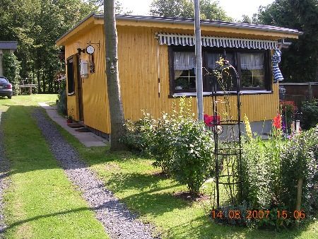 Gelbes Häuschen mit Rosenbogen auf dem Campingplatz